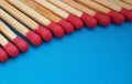 Closeup of matchsticks in a row over blue background. Royalty Free Stock Photo