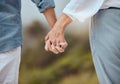 Closeup of a mature couple holding hands and enjoying a romantic stroll together on vacation at the beach. Older couple Royalty Free Stock Photo