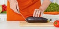 Closeup mature man`s hands cutting vegetables on a work surface in a kitchen. Royalty Free Stock Photo