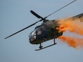 Closeup of MBB Bo105 helicopter releasing paint in the sky at an air show in Slovakia