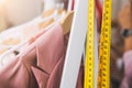 Closeup of measuring tape and line of fashion pastel pink colored woman shirts with wooden hangers in clothing shop Royalty Free Stock Photo