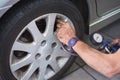 Closeup Of Mechanic At Repair Service Station Checking Tyre Pressure With Gauge . Royalty Free Stock Photo