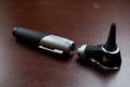 Closeup of a medical device otoscope for ear nose and throat surgeons on wooden table