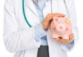 Closeup on medical doctor woman holding piggy bank Royalty Free Stock Photo