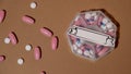 Closeup of medical pill box with doses of tablets for daily take medicine with white pink drugs and capsules with paper Royalty Free Stock Photo