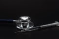 Closeup medical stethoscope and Insulin syringe to use control blood sugar level on black background. Use as Medicine, diabetes,
