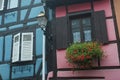 medieval house facade with red geranium at the window in the famous village of Bergheim in France