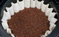 Closeup of the medium-coarse ground coffee beans settled inside a fluted white paper filter, ready for a fresh drip brew Royalty Free Stock Photo