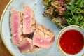 Closeup Medium rare tuna with lettuce and hot sauce. Restaurant menu