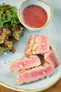 Closeup Medium rare tuna with lettuce and hot sauce. Restaurant menu