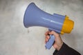 Closeup Megaphone of human hand holding on gray background Royalty Free Stock Photo