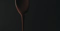 Closeup melted dark chocolate dripping from spoon over black background Royalty Free Stock Photo