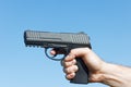 Closeup mens hand holds a 9mm gun ready to shoot Royalty Free Stock Photo