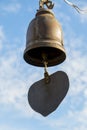 Closeup of metal buddhist bell with heart shape on sky background. Royalty Free Stock Photo