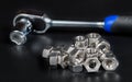 Stainless steel hexagon nuts pile with reflection and ratchet wrench on black background
