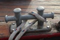 Closeup of a metal mooring bollard with a rope