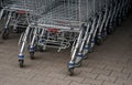 Closeup of metal shopping carts stacked in front shop mall, detail on lower part and wheels Royalty Free Stock Photo