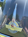 Closeup of the metallic badge on the black shiny vintage Morris Minor car
