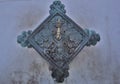 Closeup of a metallic faucet with beautiful carvings on the rhombus-shaped wall