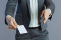 Stylish business woman giving hand for handshake against grey Royalty Free Stock Photo