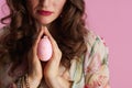 Closeup on middle aged woman with easter egg praying