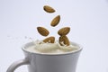 Closeup milk splash with almonds nut on white background