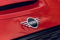 Closeup of the Mini logo on a red cooper parked outdoors Royalty Free Stock Photo