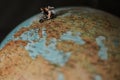 Closeup of miniature bride and groom on a motorbike on a globe surface