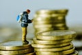 Miniature traveler on a pile of euro coins