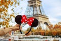 Closeup on Minnie Mouse Ears in hand in front of Eiffel tower