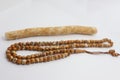 Closeup of a miswak stick and tasbih prayer beads isolated on white background