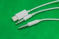 Closeup of 3.5 mm input plugs and usb plug on green background - Image