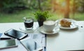 Closeup mobile phone put on investment paper chart,beside coffee cup on table