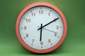 modern analog clock orange color on green background