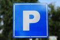 Closeup of a modern free parking sign road sign on nature park background. Isolated parking blue road sign with letter P Royalty Free Stock Photo