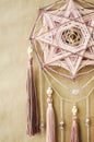Closeup modern mandala with quartz crystals, amethyst, moonstone, tassels and chain on craft paper background
