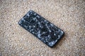 Closeup of Modern mobile smart phone with broken, cracked screen on stone floor background. Royalty Free Stock Photo