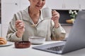 Closeup of senior woman using laptop while enjoying breakfast at home Royalty Free Stock Photo