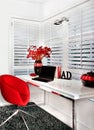 Closeup of a modern work room with a red chair a white table inc Royalty Free Stock Photo