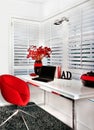 Closeup of a modern work room with a red chair a white table inc Royalty Free Stock Photo