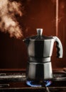 Closeup of Moka coffee pot on a gas stove Boils and lets off steam