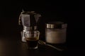 Closeup of a Moka pot with a glass mug of brewed coffee and a sugar bowl