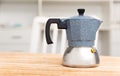 Closeup of moka pot standing on wooden table