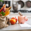 Closeup on money in piggy bank and purchases from local market Royalty Free Stock Photo