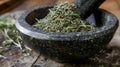 A closeup of a mortar and pestle filled with dried rosemary leaves commonly used in traditional medicine for its Royalty Free Stock Photo