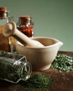 Closeup of mortar and pestle with spices and herbs on wood table Royalty Free Stock Photo