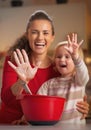 Closeup on mother and baby hands smeared in flour