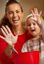 Closeup on mother and baby hands smeared in flour