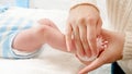 Closeup of mother cleaning newborn baby body and applying moisturizing baby oil with cotton pad Royalty Free Stock Photo