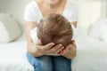 Closeup of mother`s hands holding head of sleeping 3 months old